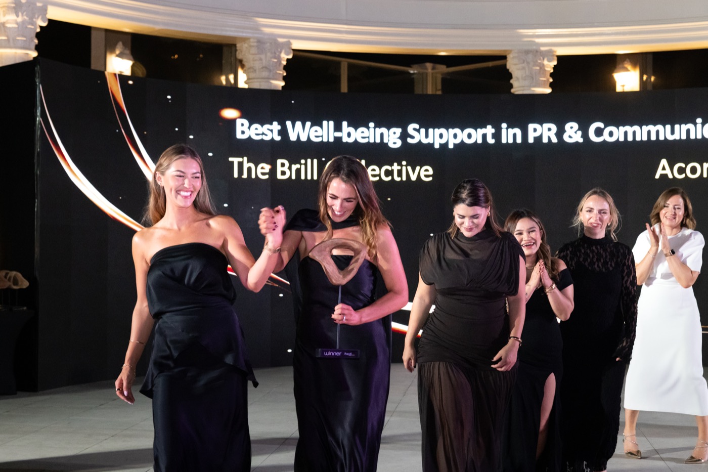 Winners celebrating together on stage at the mentl awards 2025